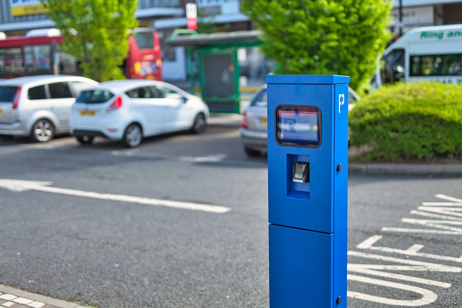 Motorist using a self-service parking payment machine in a car park